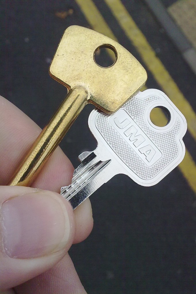 "Project 366 #296: 221012 I Hold The Key" by Comedy Nose Two keys, one silver and one bronze, held by a left hand. The silver key has 'JMA' engraved.