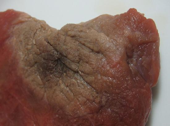 an image of freezer burn on a piece of beef, represented by an unappetizing dark section