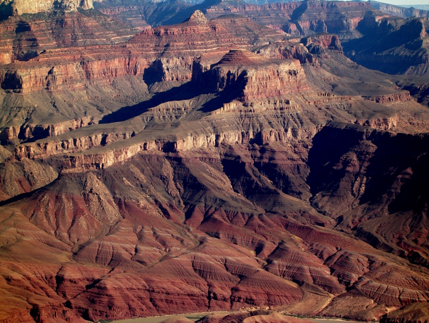 Figure 8.8 The great angular unconformity in the Grand Canyon, Arizona. The tilted rocks at the bottom are part of the Proterozoic Grand Canyon Group (aged 825 to 1,250 Ma). The flat-lying rocks at the top are Paleozoic (540 to 250 Ma). The boundary between the two (which is marked, where visible, with a dashed white line) represents a time gap of nearly 300 million years. [SE ]