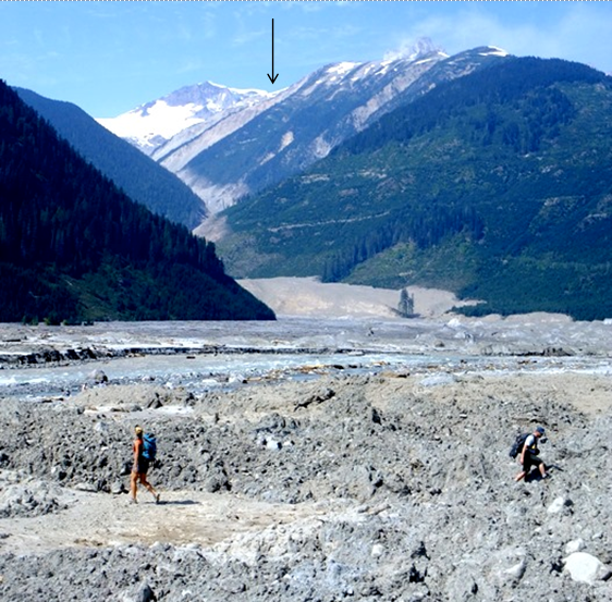 Photograph with an arrow pointing at the top of the image to where the origin of the Mt. Meager rock avalanche was.