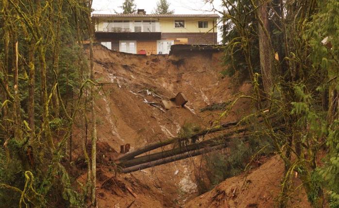 Figure 15.6 The debris flow in the Riverside Drive area of North Vancouver in January, 2005 happened during a rainy period, but was likely triggered by excess runoff related to the roads at the top of this slope and by landscape features, including a pool, in the area surrounding the house visible here. [The Province, used with permission]