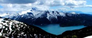 Figure 4.2 Mt. Garibaldi (background left, looking from the north) with Garibaldi Lake in the foreground. The volcanic peak in the centre is Mt. Price and the dark flat–topped peak is The Table. All three of these volcanoes were active during the last glaciation. [SE photo]