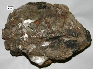 Figure 3.18 A pegmatite with mica, quartz, and tourmaline (black) from the White Elephant mine, South Dakota [from http://en.wikipedia.org/wiki/Pegmatite#mediaviewer/File:We-pegmatite.jpg]