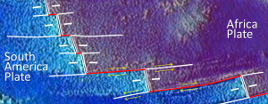 Figure 10.15 A part of the mid-Atlantic ridge near the equator. The double white lines are spreading ridges. The solid white lines are fracture zones. As shown by the yellow arrows, the relative motion of the plates on either side of the fracture zones can be similar (arrows pointing the same direction) or opposite (arrows pointing opposite directions). Transform faults (red lines) are in between the ridge segments, where the yellow arrows point in opposite directions. [SE]